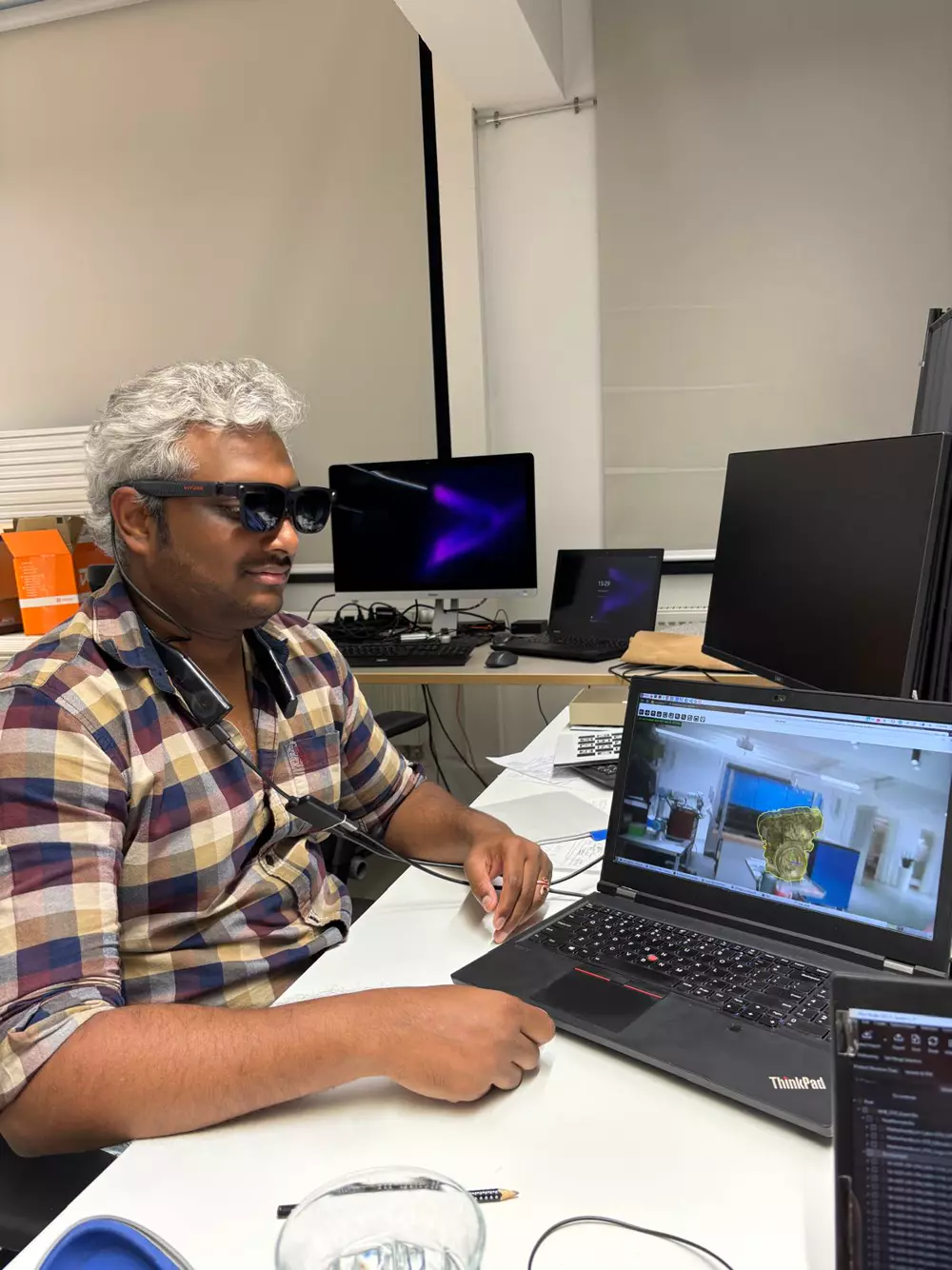 Me wearing the Viture glasses and neckband, with the engine pose tracked on the glasses' camera stream on the laptop.