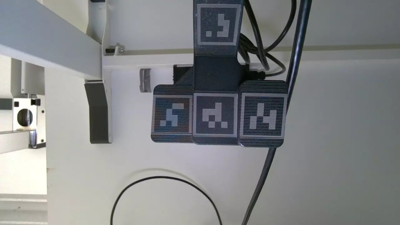 The calibration part: designed with the tool-tip frame and tag positions (left), printed with laser-written AprilTags (right).